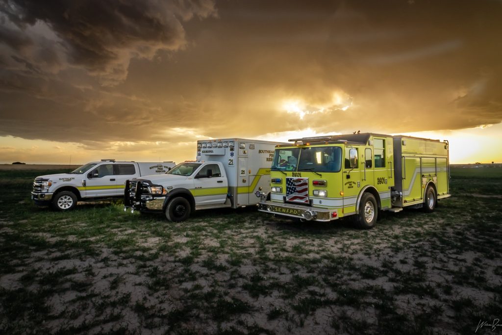 A fire engine, ambulance, and battalion chief's truck at sunset